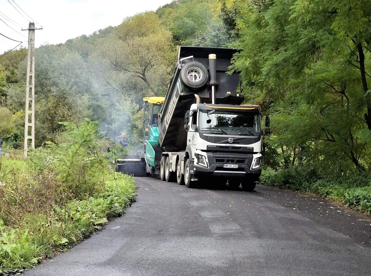 Finisheres aszfaltozás erdei úton, billencs tölti a finishert