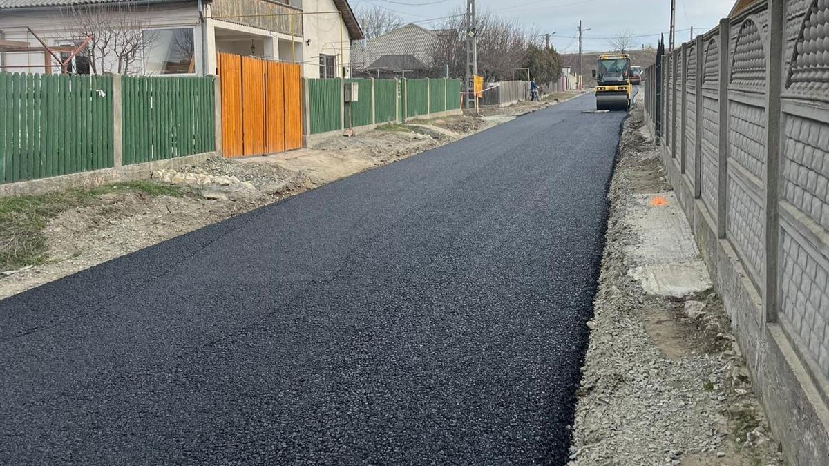 Frissen aszfaltozott belterületi utca, henger a háttérben